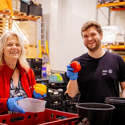 Tafel-Tandem Teilnehmer:innen sortieren Lebensmittel in Kisten