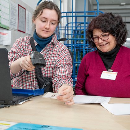 Eine ehrenamtliche Helferin scannt einen Ausweis in der Tafel.